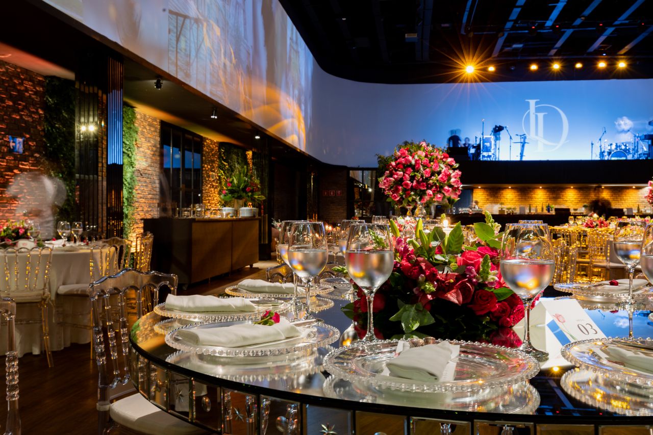Luxurious wedding venue with detailed table settings, glassware, and vibrant floral arrangements.